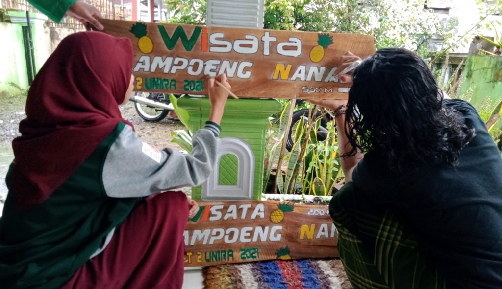 KKN-T Unira Malang Sulap Kayu Sisa Pembangunan Jadi Fasilitas Wisata Kampung Nanas Pengecatan papan nama yang dilakukan oleh mahasiswa KKN Unira Malang