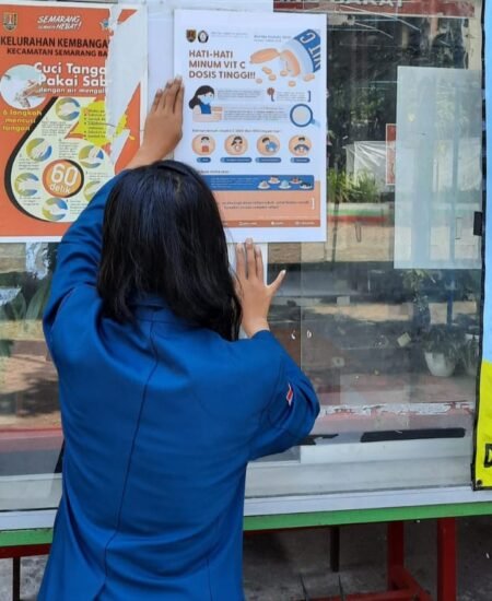 Mahasiswa UNDIP Edukasi Warga Terkait Aturan Konsumsi Vitamin C Mahasiswa Undip saat menempelkan poster edukasi dosis minum vitamin C