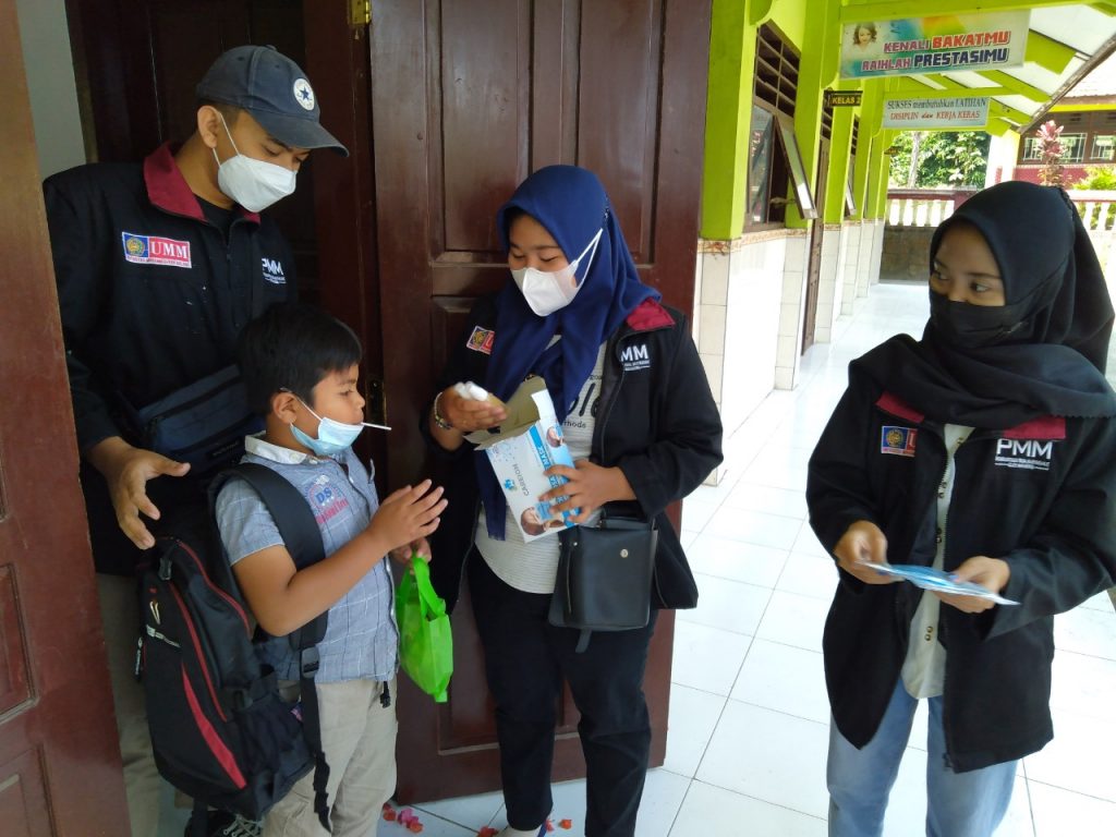 Bagikan Masker, Mahasiswa PMM UMM Edukasi Warga dan Siswa secara Door to Door Mahasiswa PMM UMM saat melakukan edukasi dan pembagian masker pada warga dan siswa