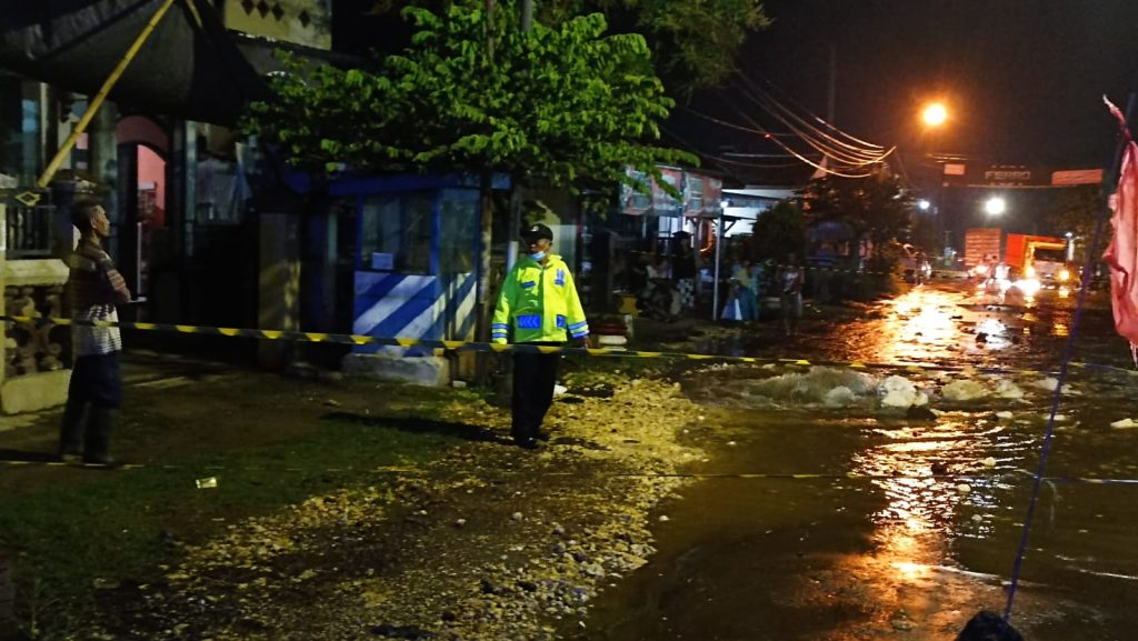 Pipa PDAM Bocor, Petugas Polsek Tumpang Sigap Amankan Lokasi Petugas Polsek Tumpang saat melakukan pengamanan lokasi bocornya Pipa PDAM di Jalan Raya Pulungdowo, Kecamatan Tumpang, Kabupaten Malang
