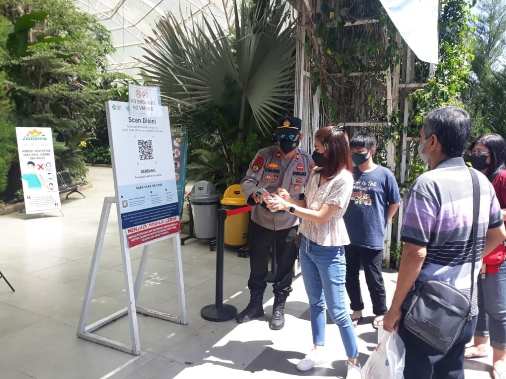 Lonjakan Wisatawan, Polres Batu Minta Perketat Prokes di Semua Kawasan Wisata Anggota Polres Batu saat memberikan edukasi kepada pengunjung wisata